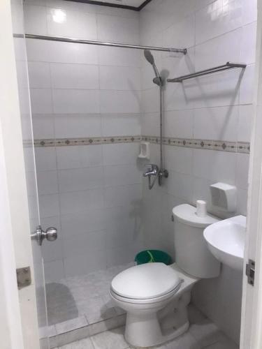 a white bathroom with a toilet and a sink at Casa De Soledad Vigan City in Vigan