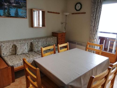 une salle à manger avec une table, des chaises et un canapé dans l'établissement 2 pièces cabine, pied des pistes, 5 pers, balcon - FR-1-557-69, à Les Adrets