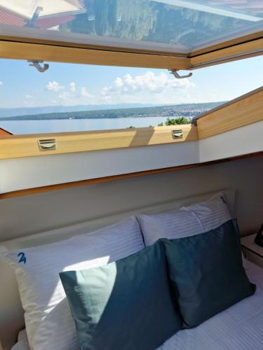 a bedroom with a large window above a bed at Anna24 Holidays in Vantačići