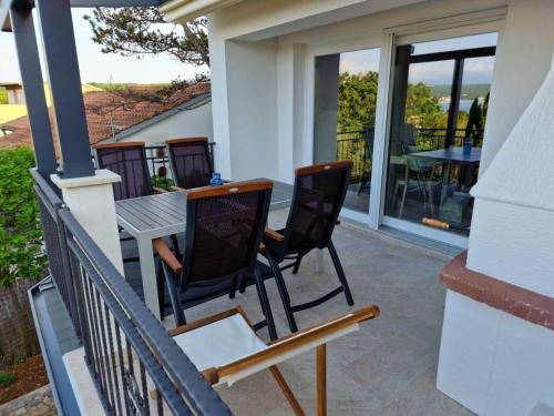 a patio with two chairs and a table on a porch at Anna24 Holidays in Vantačići