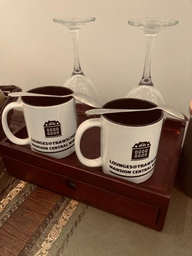 two mugs and two wine glasses on a wooden tray at Trawscoed Mansion,Central Wing in Aberystwyth