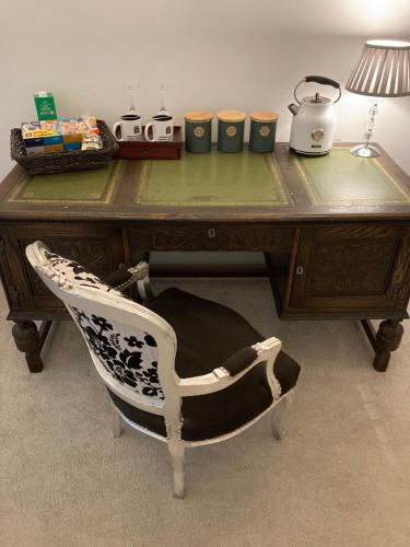 a desk with a chair and a table with a lamp at Trawscoed Mansion,Central Wing in Aberystwyth