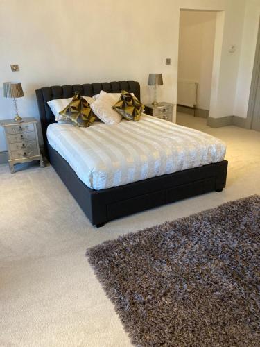 a bedroom with a bed with a black frame and a rug at Trawscoed Mansion,Central Wing in Aberystwyth
