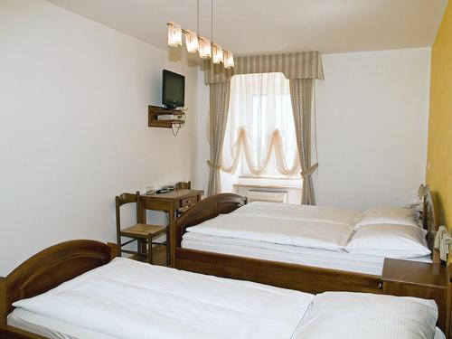 two beds in a hotel room with a window at Bed&Breakfast Kvarner in Labin
