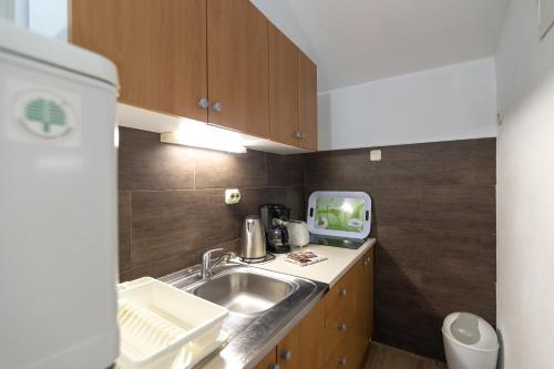 a small kitchen with a sink and a tv at Apartment Žuna in Senj