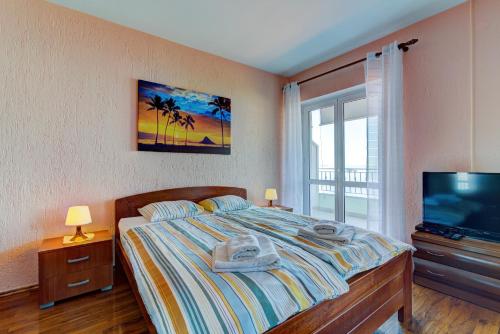 a bedroom with a bed and a flat screen tv at Apartment Žuna in Senj