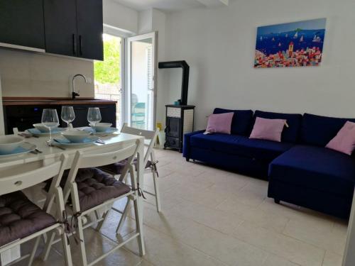 a living room with a table and a blue couch at Anna24 Holidays in Vantačići