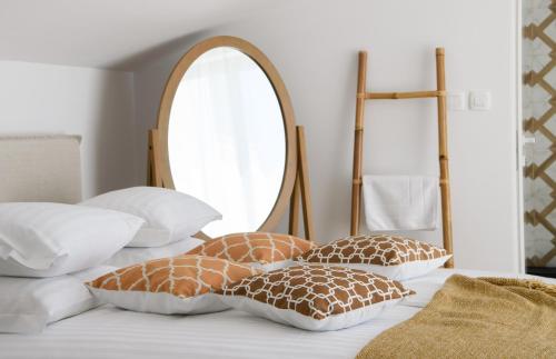 a bed with four pillows and a mirror on it at Gallery Luxury Suites & Rooms-Only Adults in Split