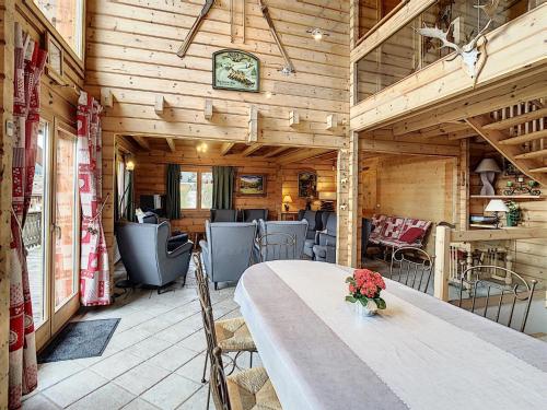 une salle à manger avec une table, des chaises et une horloge dans l'établissement Chalet confortable face aux pistes – 13 couchages, garage, ski room, proche Combloux et Megève - FR-1-560-36, à Demi-Quartier
