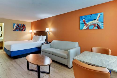 a hotel room with a bed a couch and a chair at Captains Quarters Inn in Port Aransas
