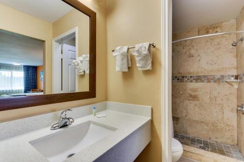 a bathroom with a sink and a toilet and a mirror at Captains Quarters Inn in Port Aransas