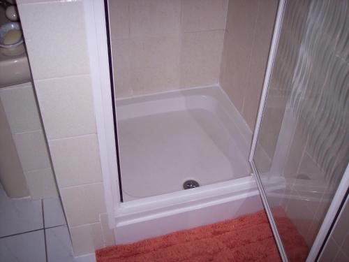 y baño con ducha y puerta de cristal. en Butterfly Guest House en Cheadle