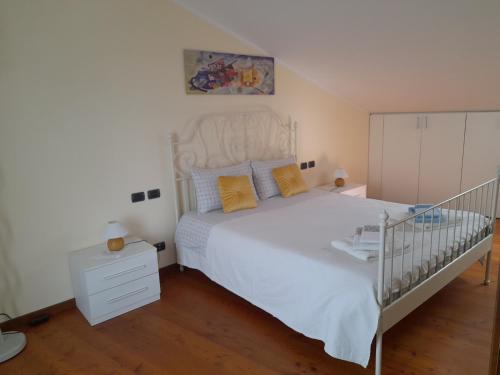 sypialnia z białym łóżkiem i białą komodą w obiekcie La casetta sui colli w mieście Perarolo