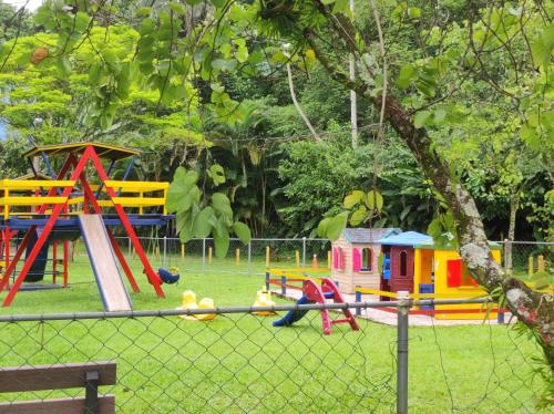 a playground with colorful play equipment in a park at Refúgio da família - serra & lago in Guapimirim