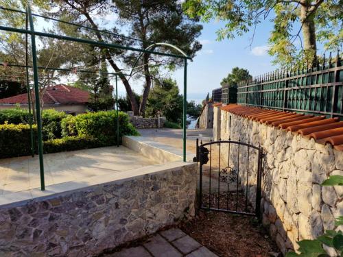 a stone wall with a gate on a sidewalk at Anna24 Holidays in Vantačići