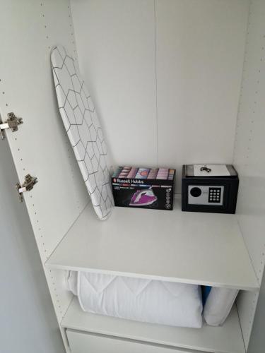 a white closet with a shelf with a clock and books at Anna24 Holidays in Vantačići