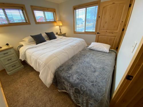 a bedroom with a large bed and a ottoman next to it at The Raspberry Garden in Rexburg