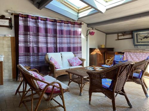 - un salon avec des chaises, une table et un canapé dans l'établissement Charmante maisonnette 3 pièces avec jardin et terrasse privés à Erdeven, proche plages et commerces - FR-1-397-47, à Erdeven