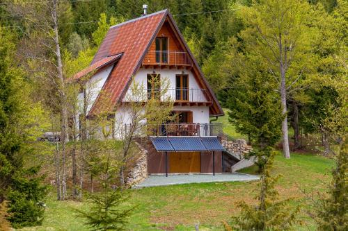 a house with a red roof in the woods at Mountain house Beauty of Laz in Ravna Gora