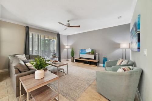 a living room with a couch and a tv at Paradise Villa Disney Staycation Pool, Fun & Resort Access in Kissimmee