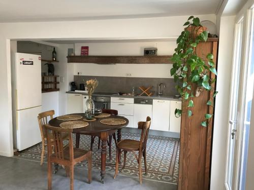 une cuisine avec une table, des chaises et un réfrigérateur dans l'établissement Appartement climatisé avec terrasse, à Carcassonne