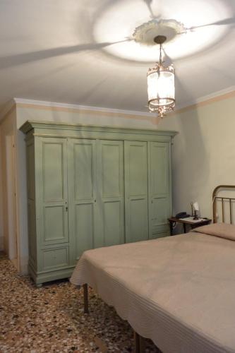 a bedroom with a green cabinet and a ceiling at Pensione Seguso in Venice