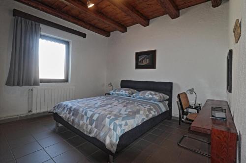 a bedroom with a bed and a desk and a window at Two Olives in Vrbnik