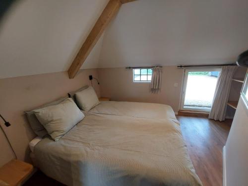 a bedroom with a bed in a room with a window at Eursingerhof in Havelte