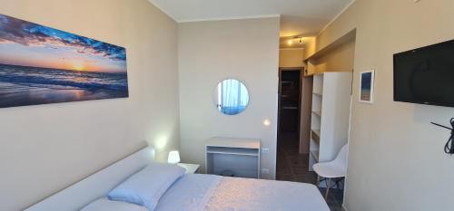 a bedroom with a bed and a flat screen tv at B&B Aria di Mare - Pollina Sicilia in Finale