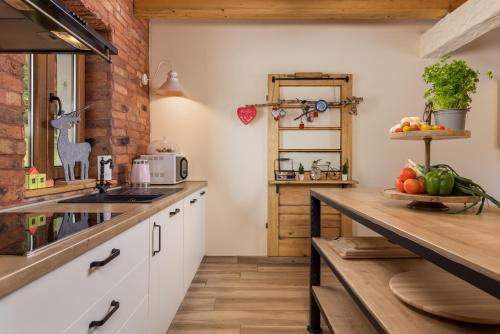 a kitchen with white cabinets and a wooden counter top at Mountain house Beauty of Laz in Ravna Gora