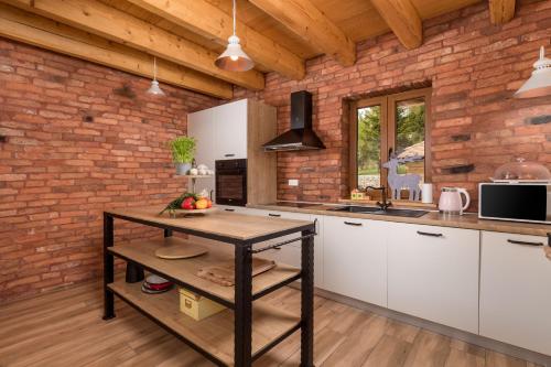 a kitchen with white cabinets and a brick wall at Mountain house Beauty of Laz in Ravna Gora