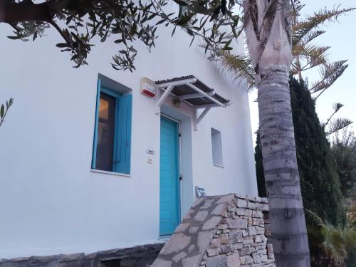 una casa con una puerta azul junto a una palmera en Villa Sofi in Saint George Antiparos (pool&sea) en Andíparos