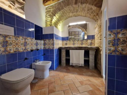 Baño de azulejos azules con aseo y lavamanos en Antica Dimora Aragonese, en Agropoli
