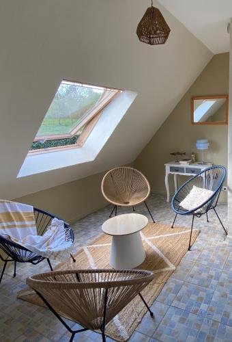 une chambre avec des chaises, des tables et une fenêtre dans l'établissement La Pichonnière, à Isigny-le-Buat