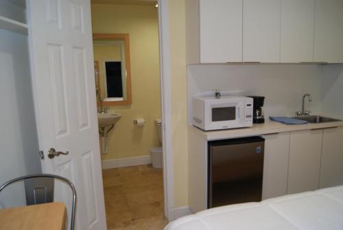 a kitchen with a microwave on top of a counter at Private Studio two miles from Hard Rock Stadium in Miami Gardens