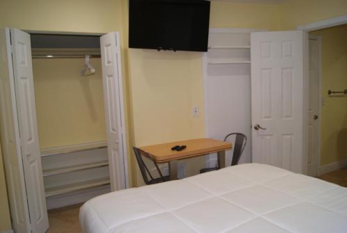 a bedroom with a bed and a table and a television at Private Studio two miles from Hard Rock Stadium in Miami Gardens