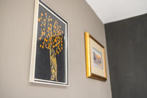 two framed pictures of a tree on a wall at Piran Holiday Apartments in the city center in Piran