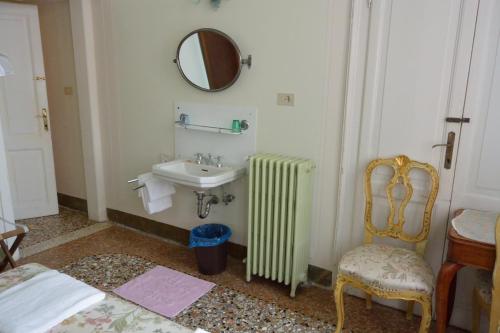 a bathroom with a sink and a radiator and a mirror at Pensione Seguso in Venice