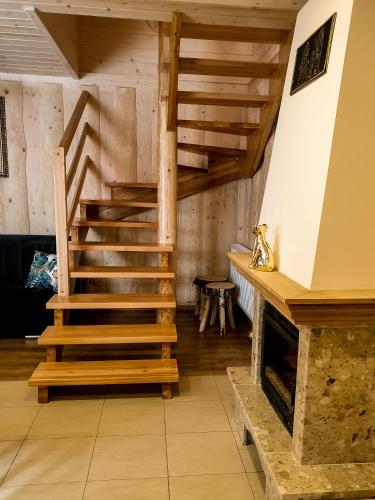 a wooden staircase in a room with a fireplace at Dwór Pan Tadeusz in Orawka