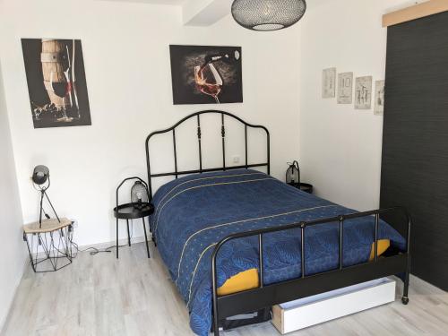 a bedroom with a bed with a blue comforter at Chambre double indépendante HARMONIE au sein du domaine PASSELOUP in Liergues