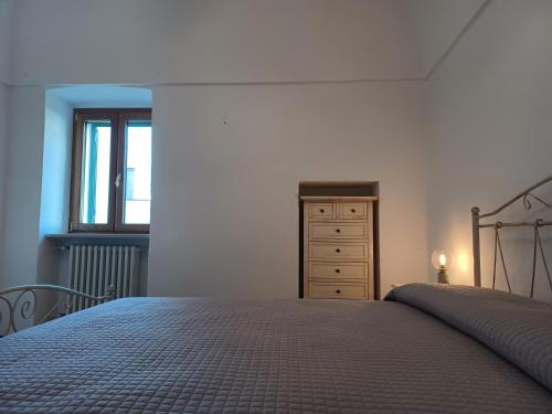 een slaapkamer met een bed, een dressoir en een raam bij Casa Fortuna in Cisternino