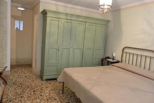 a bedroom with a green cabinet and a bed at Pensione Seguso in Venice