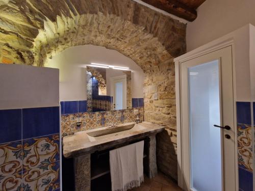 baño con lavabo y pared de piedra en Antica Dimora Aragonese, en Agropoli