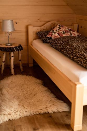 a bedroom with a bed and a table with a lamp at Dwór Pan Tadeusz in Orawka