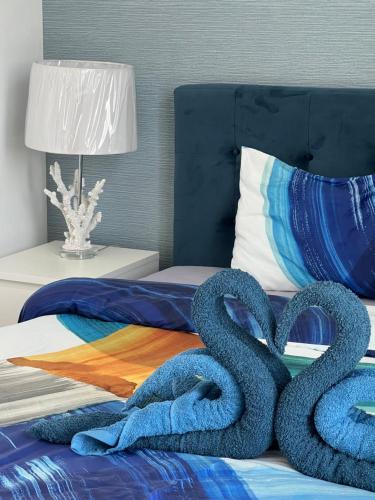 a bed with two large blue swans on it at Relaxing villa with access to pool and beach in Ras al Khaimah