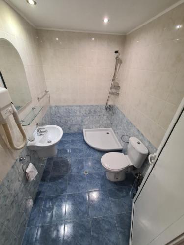a bathroom with a toilet and a bidet and a sink at Семеен хотел Аристо in Dryanovo