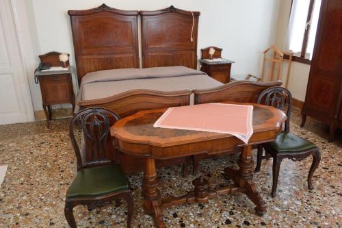 a bedroom with a bed and a wooden table and chairs at Pensione Seguso in Venice