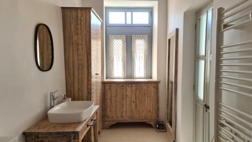 a bathroom with a sink and a mirror and a window at Townhouse Christos in Panormos Skopelos