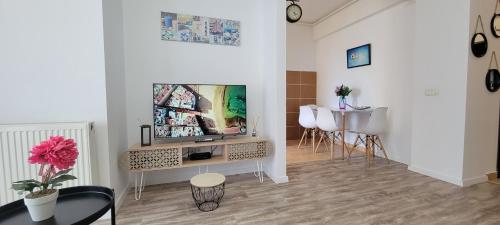 een woonkamer met een tv en een tafel bij Ionut Summerland Apartments Mamaia in Mamaia