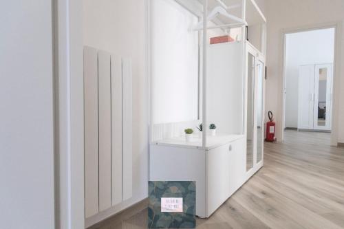 Cette chambre blanche dispose d'un lavabo et d'un miroir. dans l'établissement La casa di Elia e Italo, à Ostie